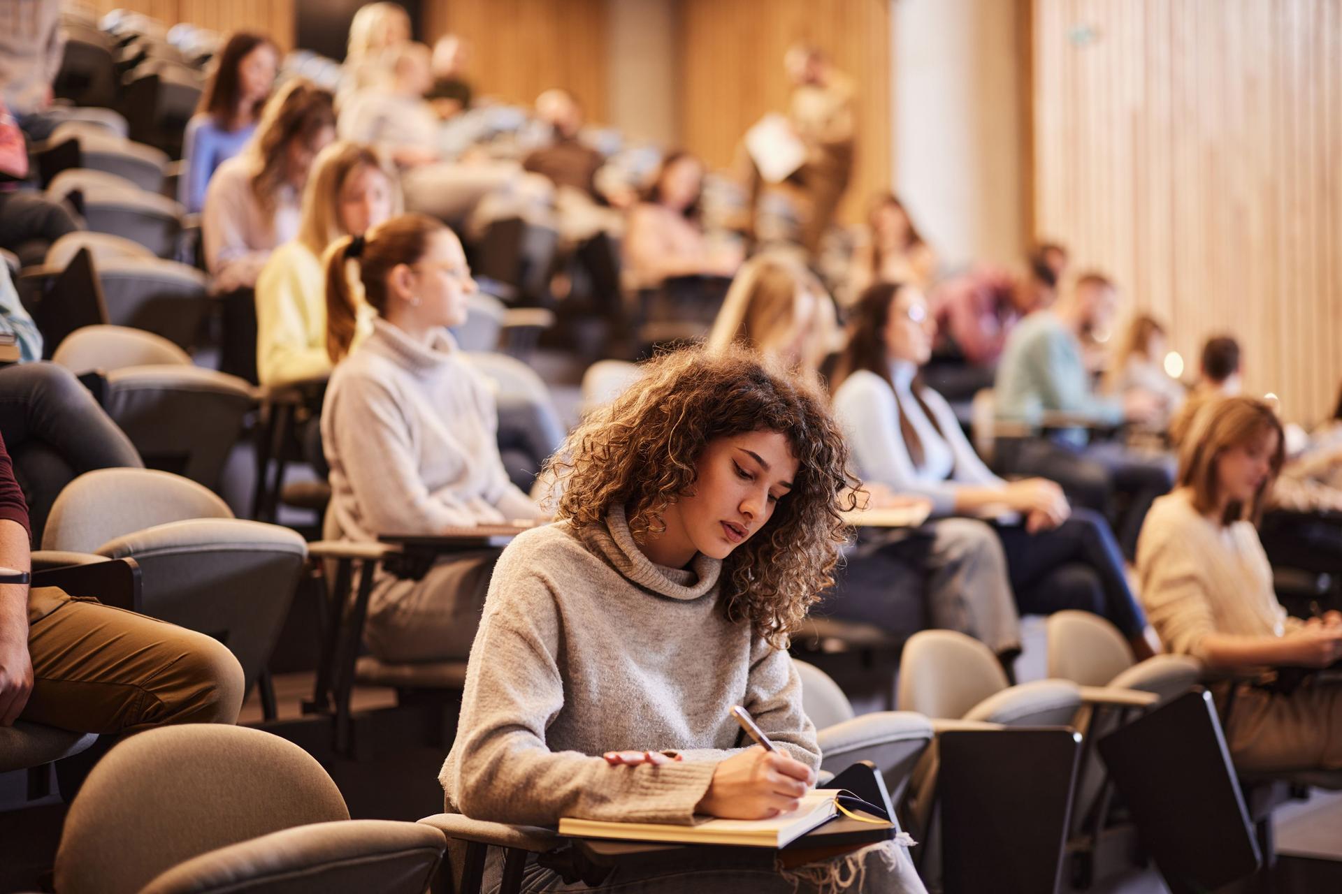 Students gathered in a lecture hall, focused on the presentation, embodying a collaborative study atmosphere.